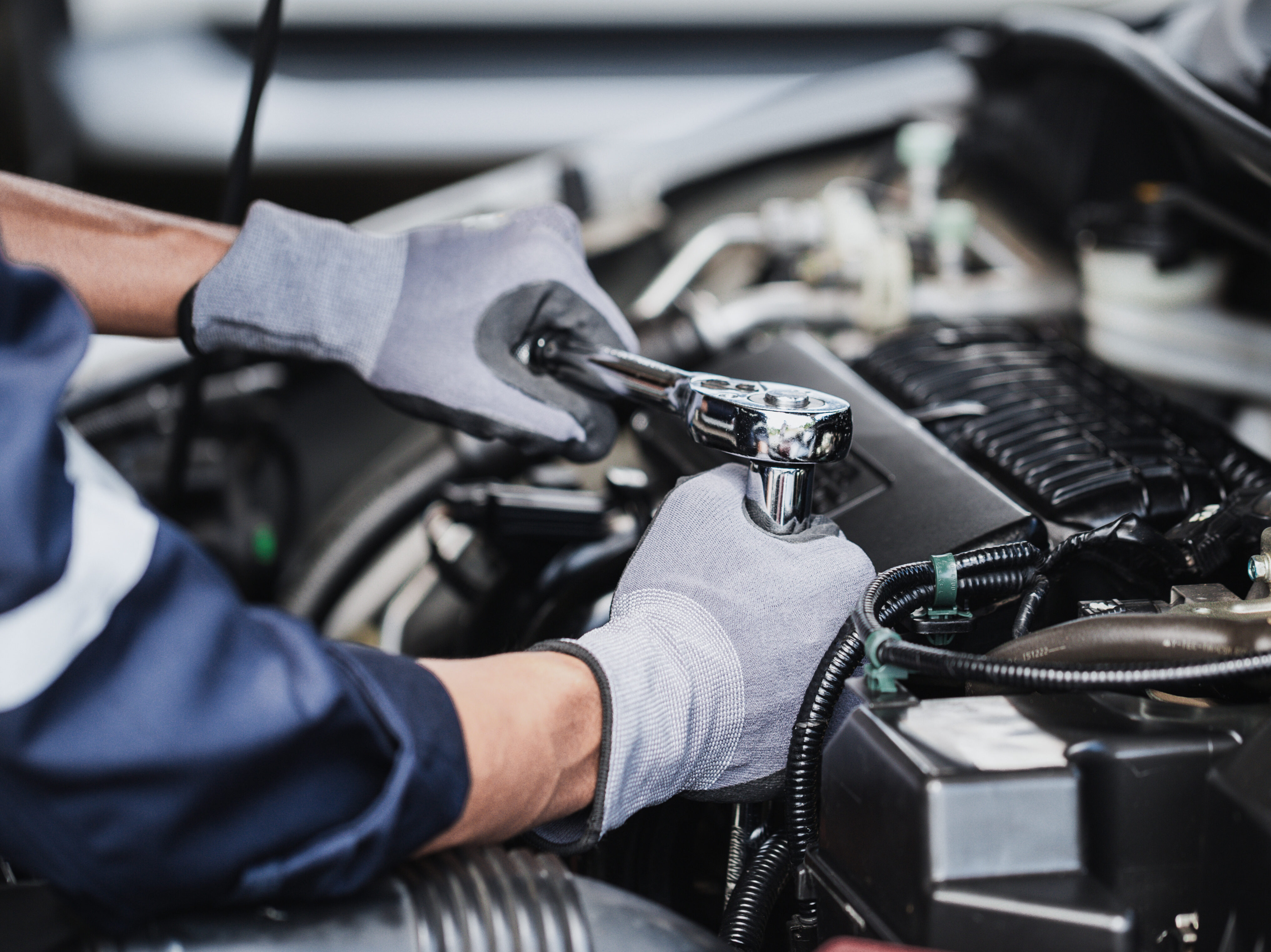 Professional mechanic working on the engine of the car in the ga